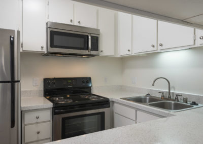 Kitchen with stainless steel oven, refrigerator and sink